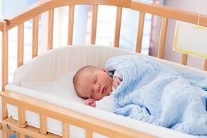 Baby im Beistellbett im Elternschlafzimmer kann vor plötzlichen Kindstod schützen